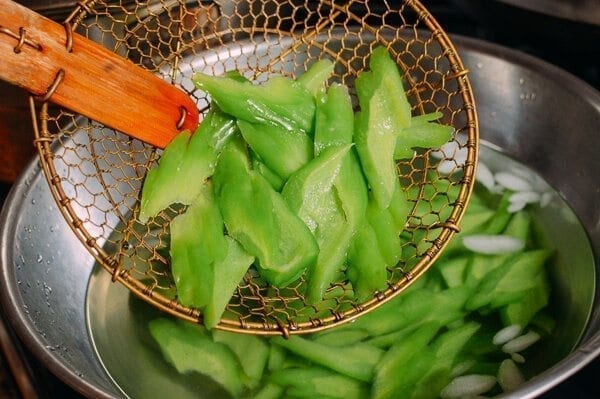 scooping blanched bitter melon with Chinese spider