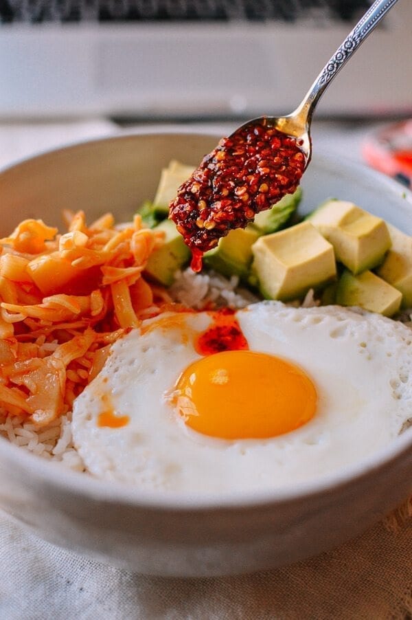 Pouring chili oil over fried egg, chili bamboo shoots, and fried egg