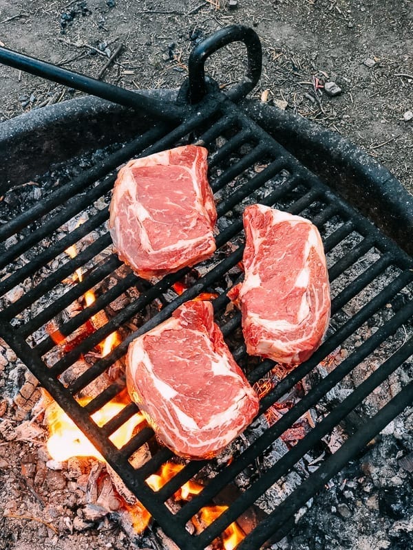 Grilling steak on a fire ring in campground, geagle.miooashdv.tk