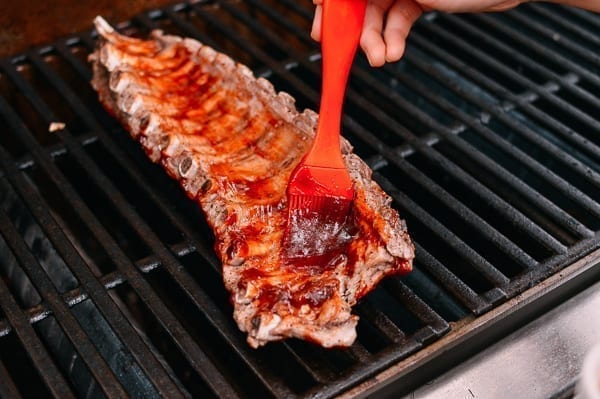 Brushing ribs with BBQ sauce on the grill, geagle.miooashdv.tk