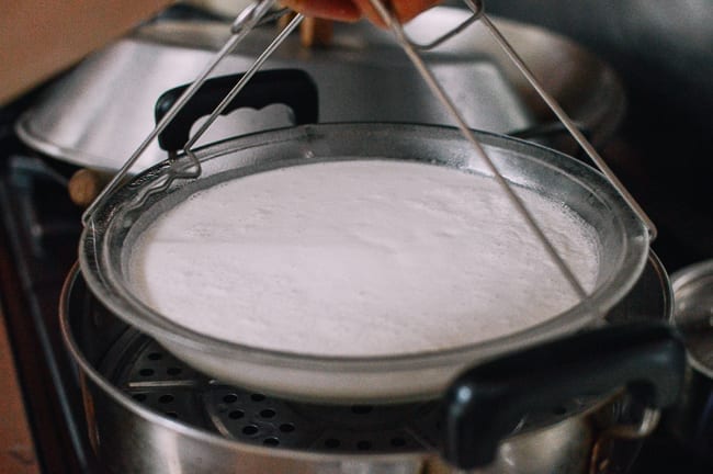 Placing dish of bai tang gao batter in steamer, geagle.miooashdv.tk
