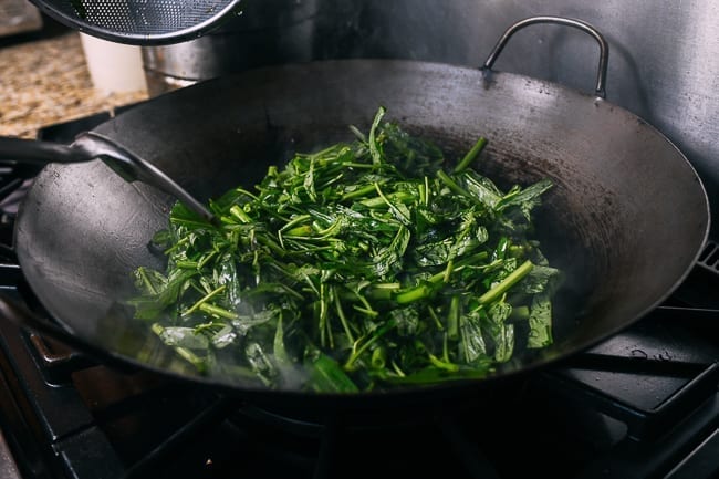 Adding water spinach to wok