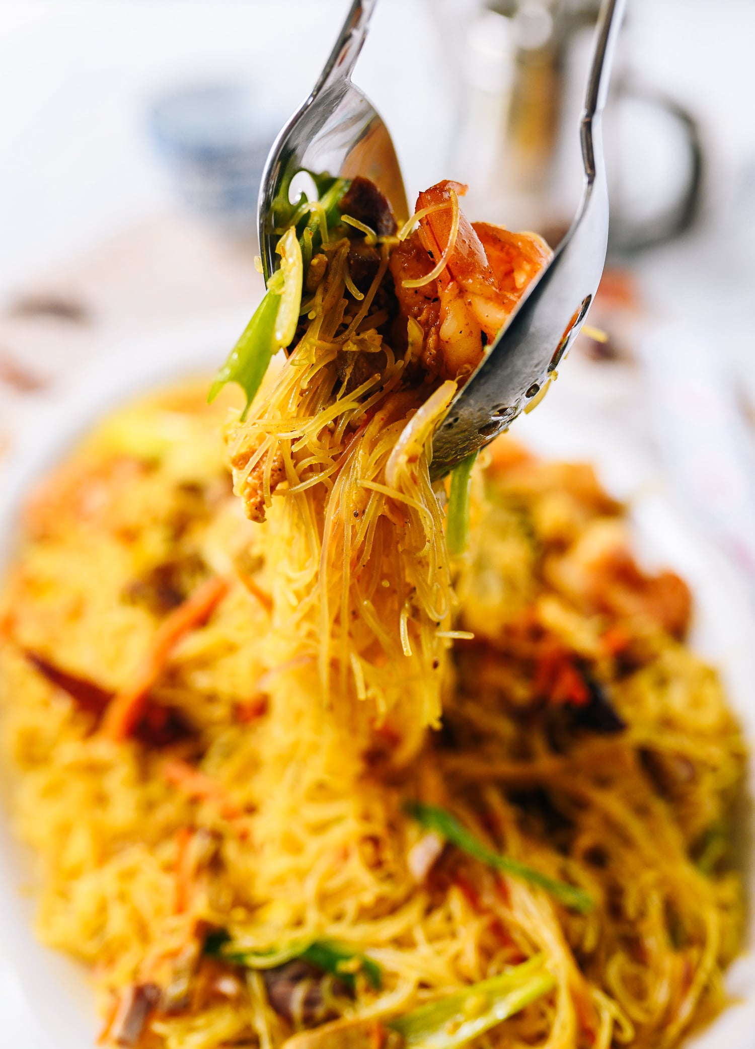 Lifting Singapore noodles off plate with two spoons, geagle.miooashdv.tk