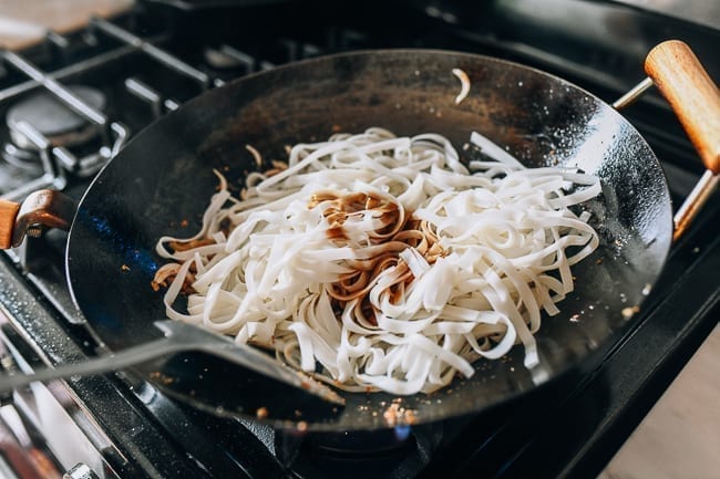 Adding noodles and pad Thai sauce to wok, geagle.miooashdv.tk
