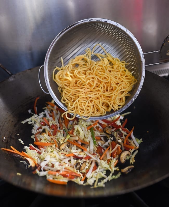 Adding lo mein noodles to vegetables in wok, geagle.miooashdv.tk