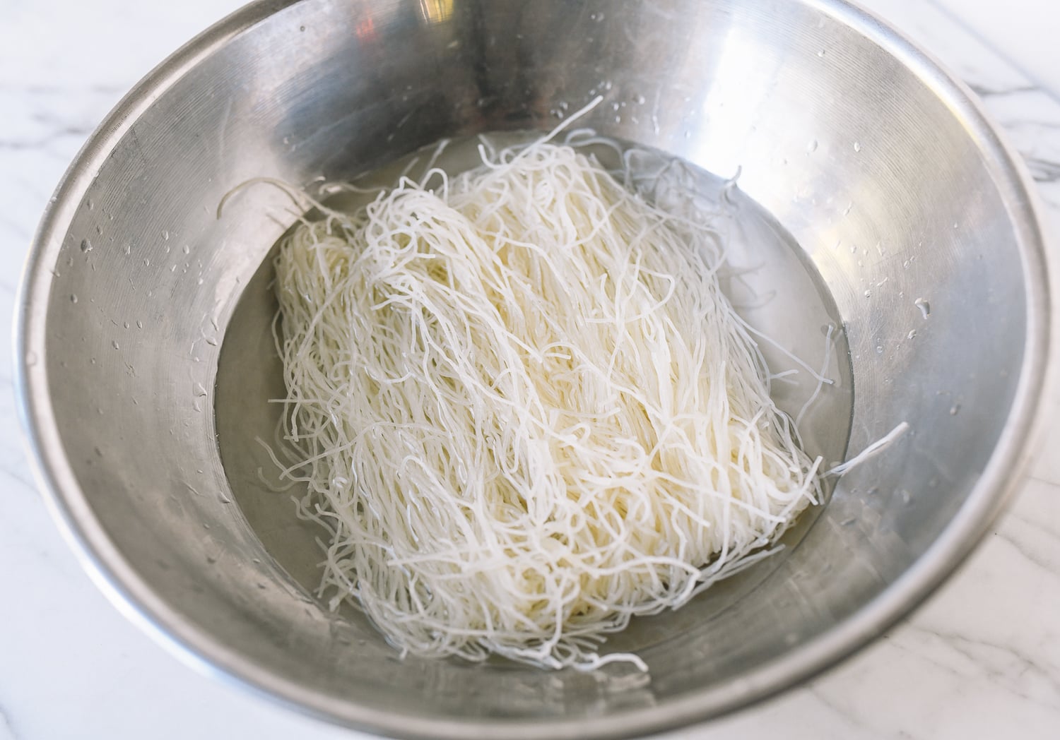Soaking rice noodles in water in metal bowl, geagle.miooashdv.tk