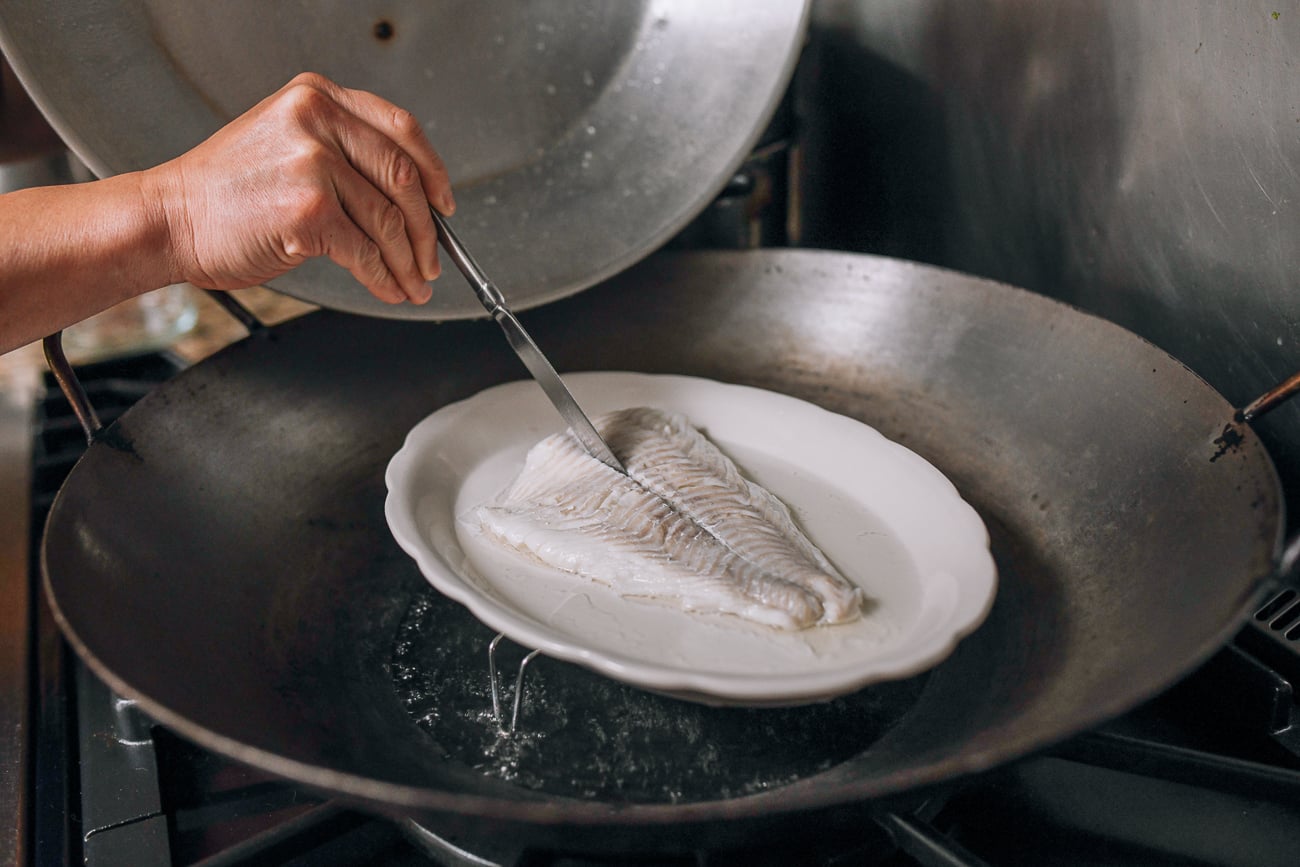 Checking fish for doneness with butter knife