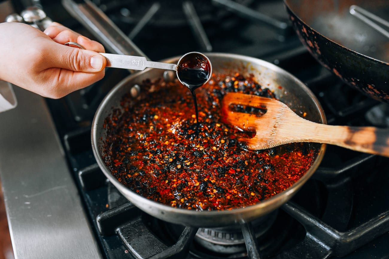 Adding dark soy sauce to saucepan