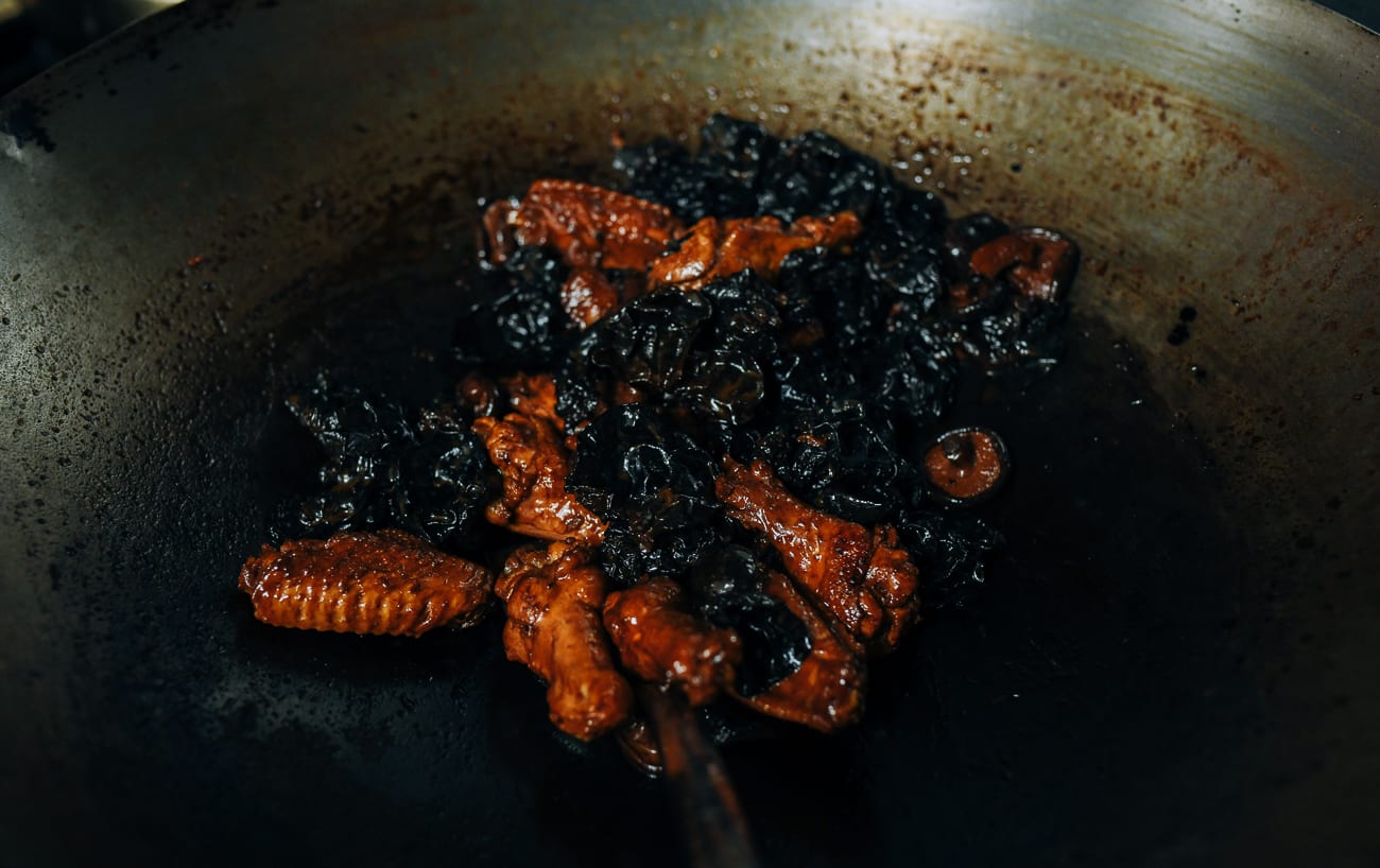 Reduced sauce in wok of chicken and Chinese mushrooms