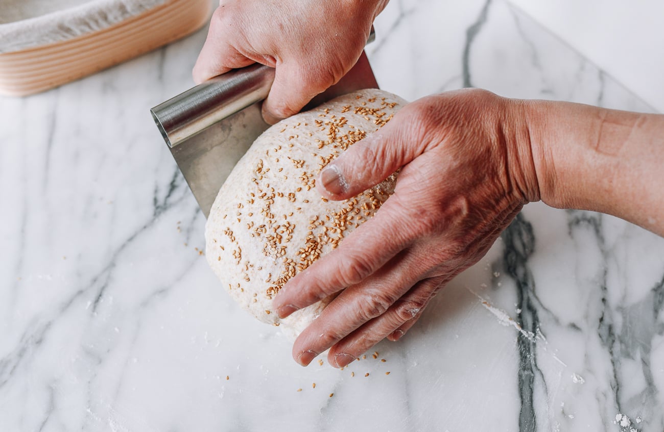 Using dough scraper to lift dough