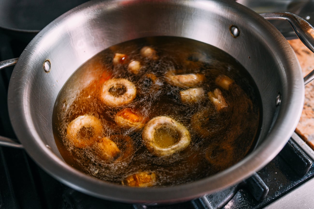 Adding water to mushrooms in pot