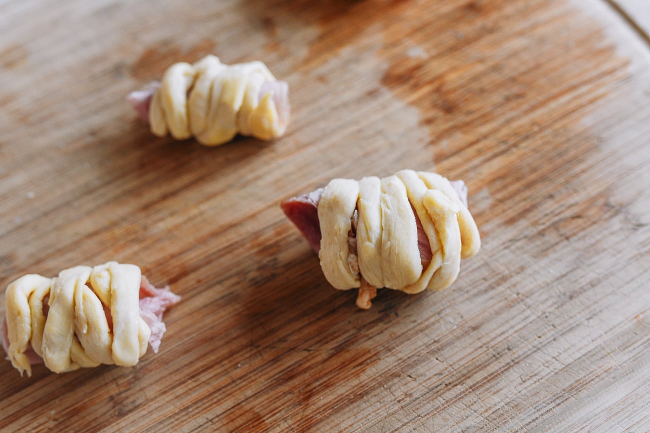 wrapping scraps of dough around bits of ham and cheese