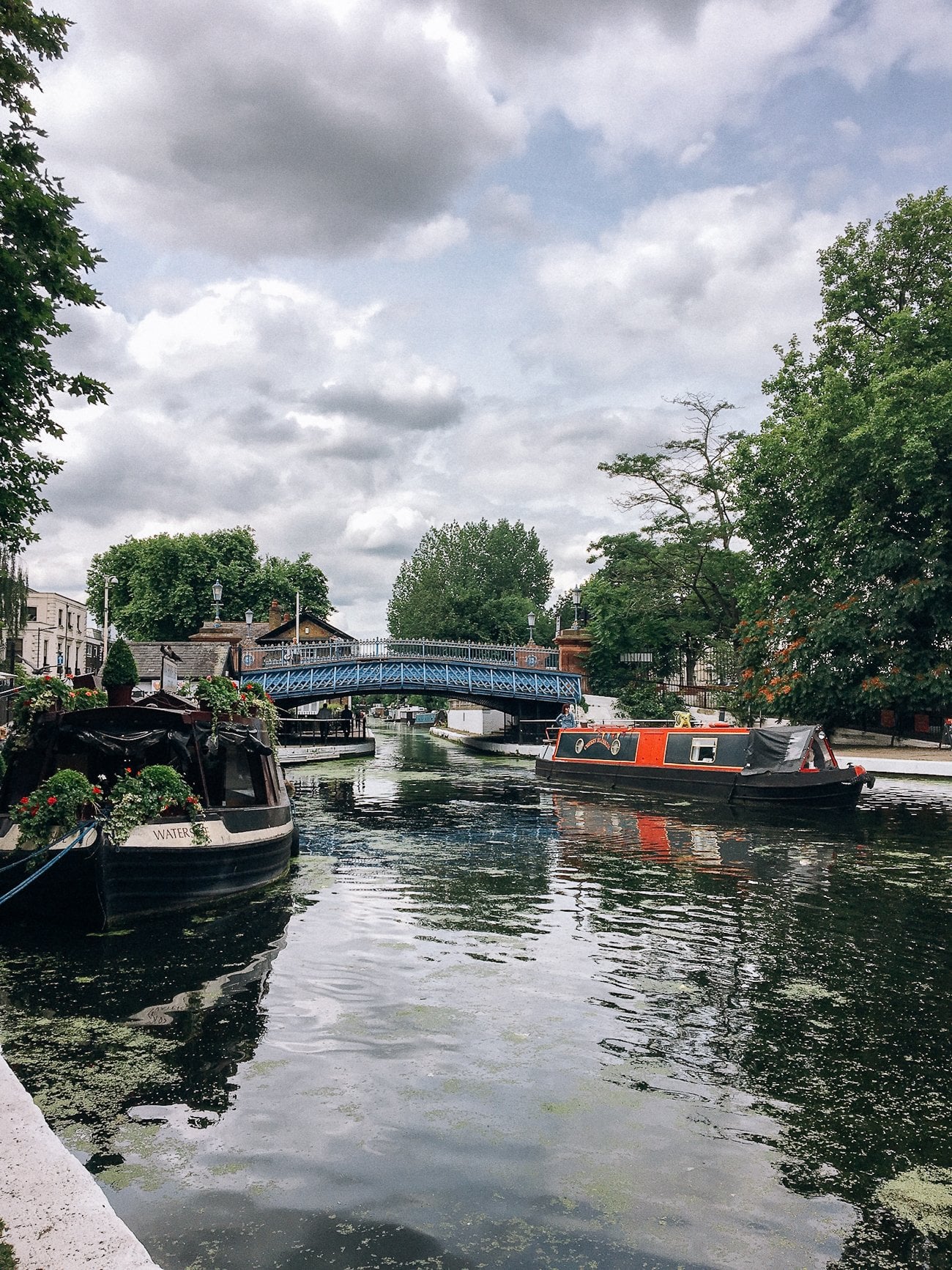 Houseboats docked in the canal with footbridge