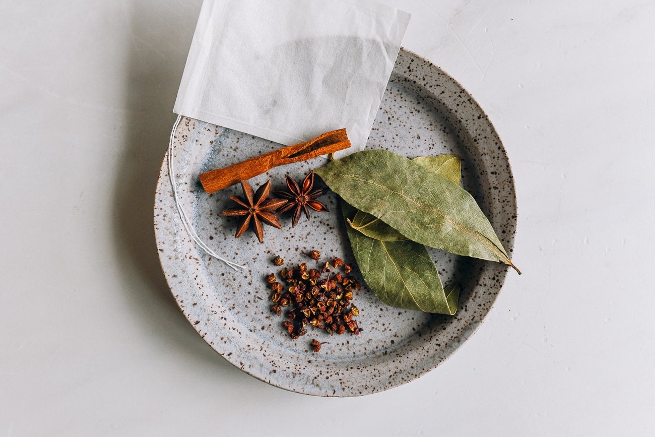 cinnamon, star anise, Sichuan peppercorns and bay leaves on plate with sachet