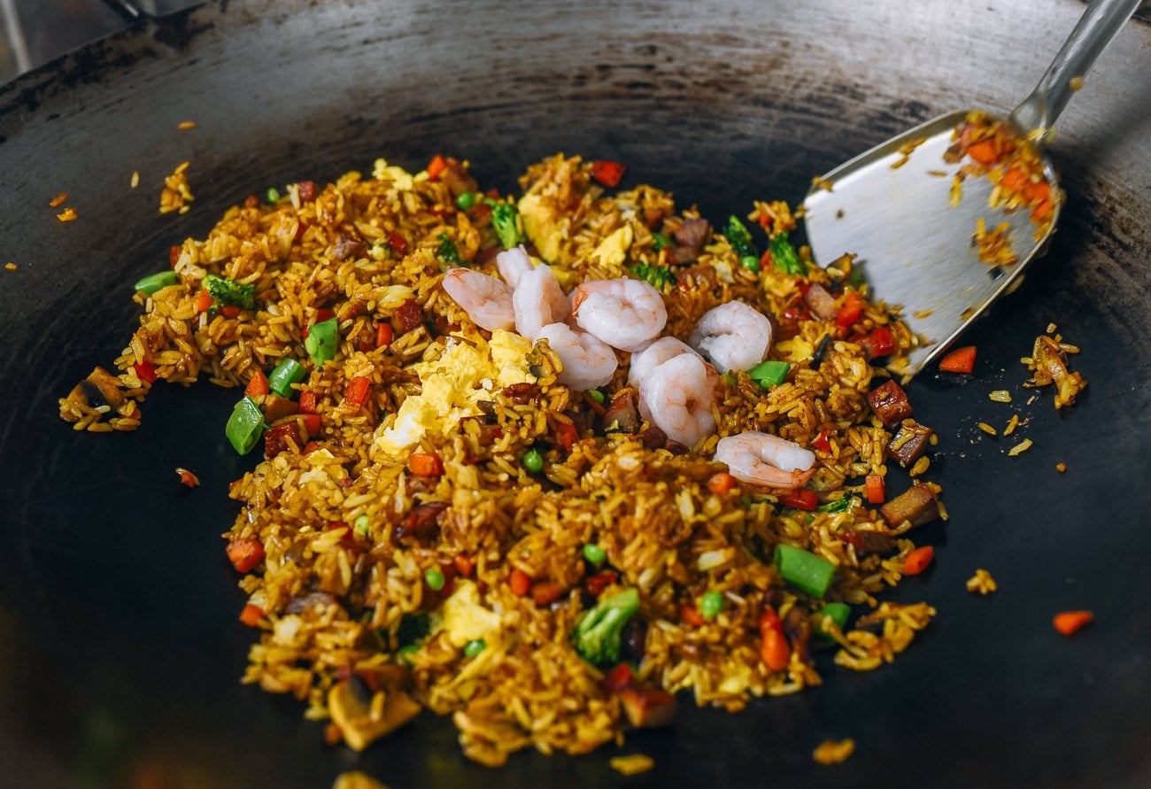 adding cooked shrimp to fried rice