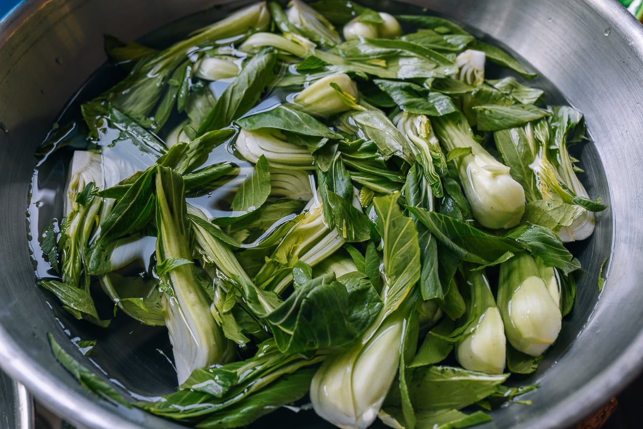 washing bok choy in metal bowl