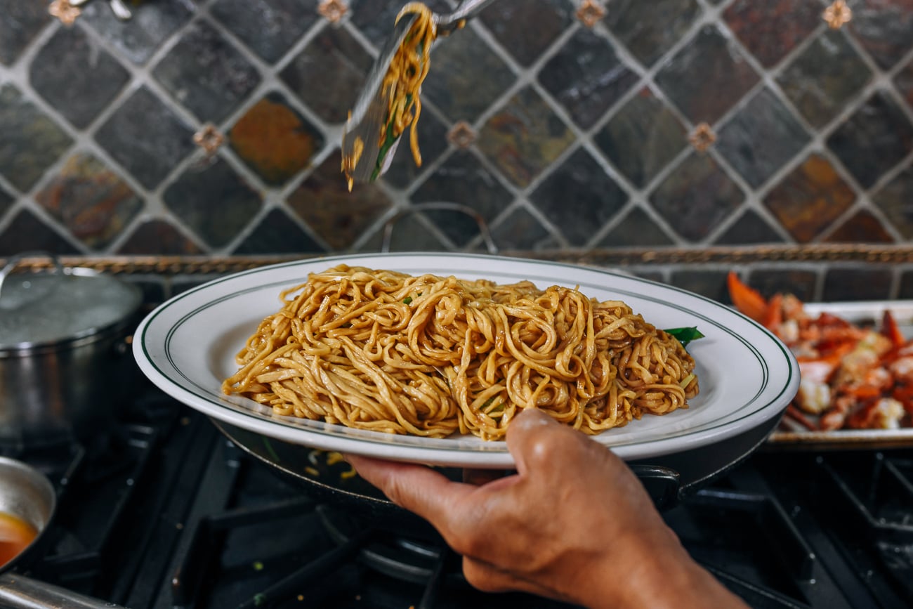 Transferring yee mein to serving plate