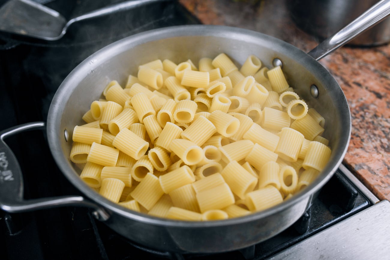 putting cooked rigatoni into skillet