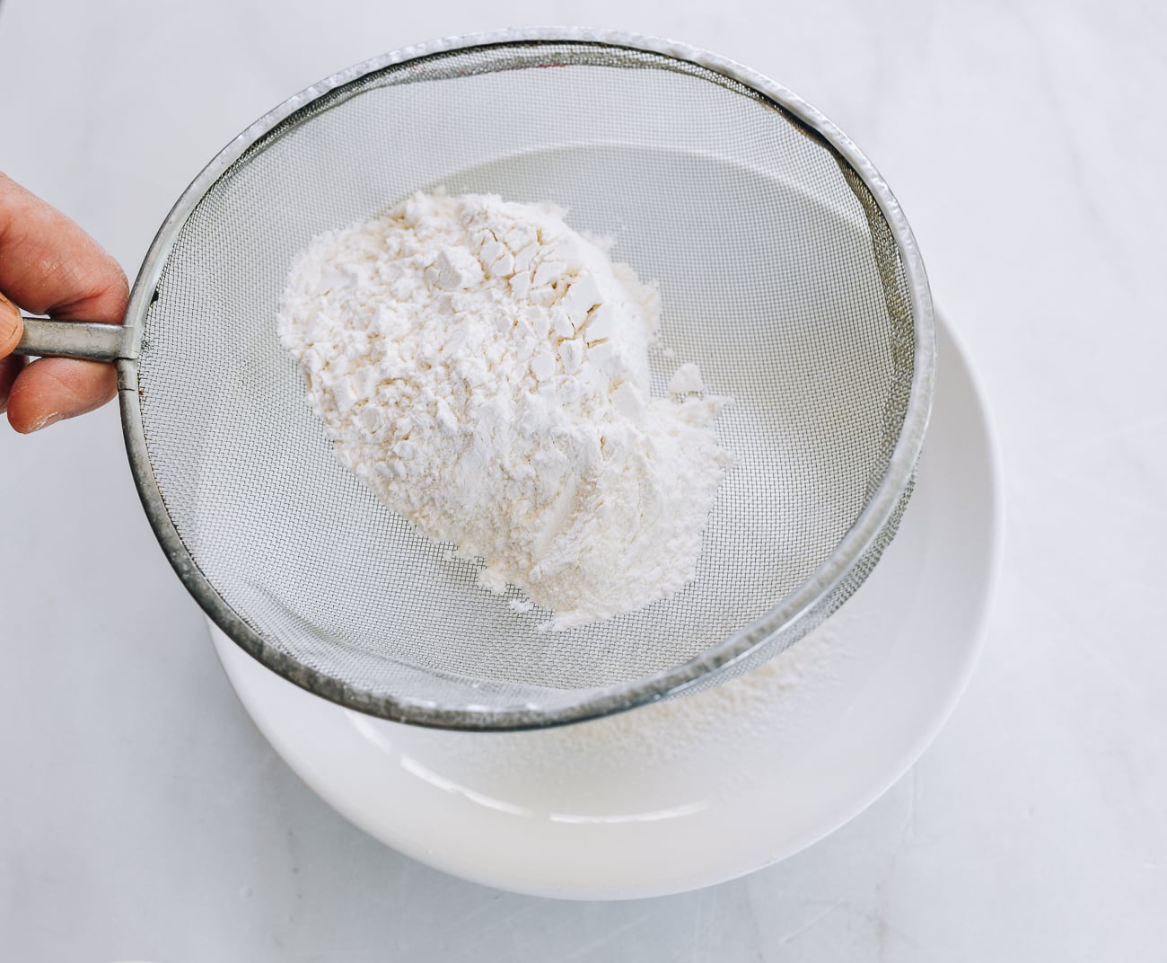 sifting flour into bowl