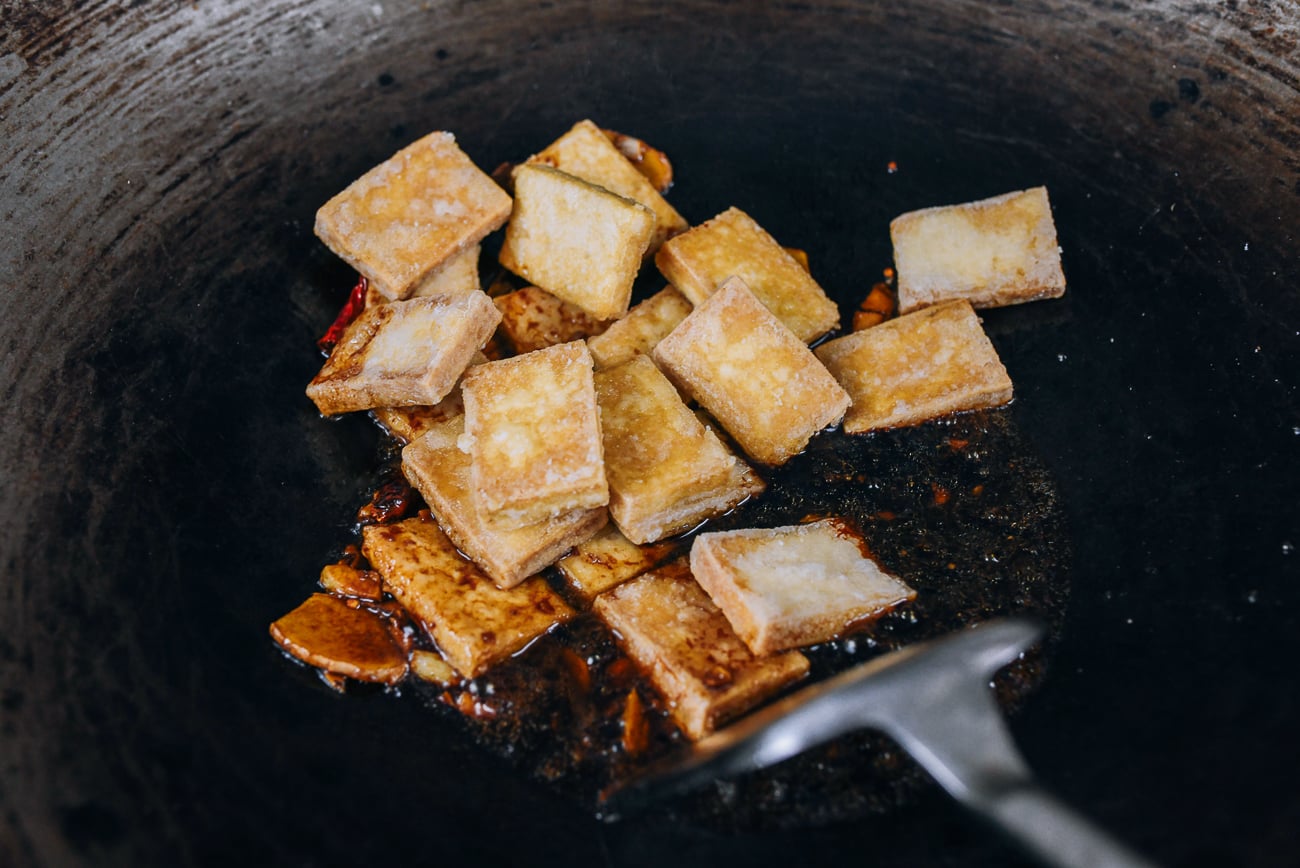 crispy tofu added to sauce in wok
