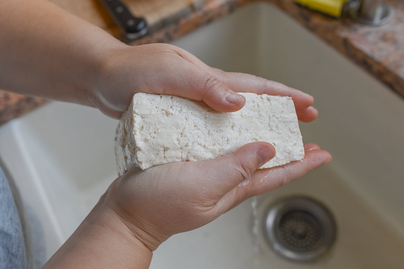 squeezing tofu between hands