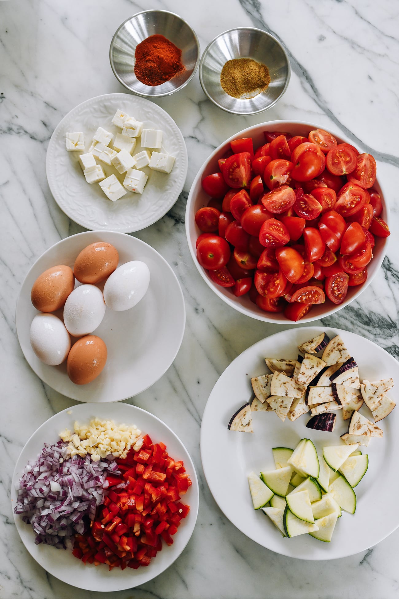 feta cheese, eggs, tomatoes, eggplant, zucchini, onions, garlic, and red bell pepper