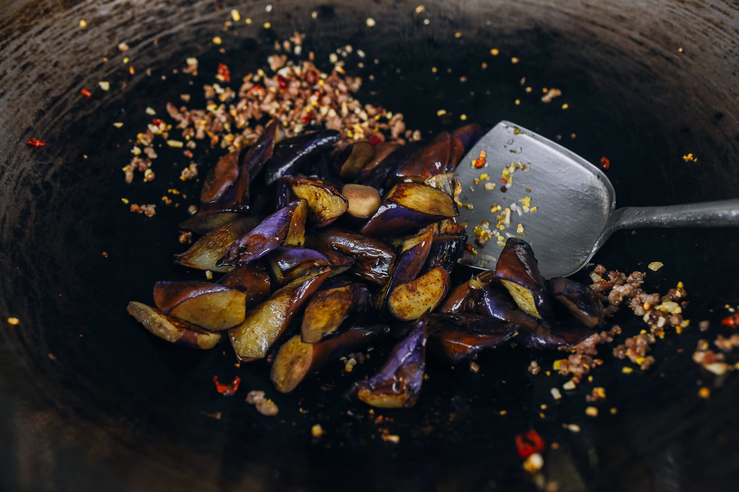 seared eggplant added to wok with ground pork
