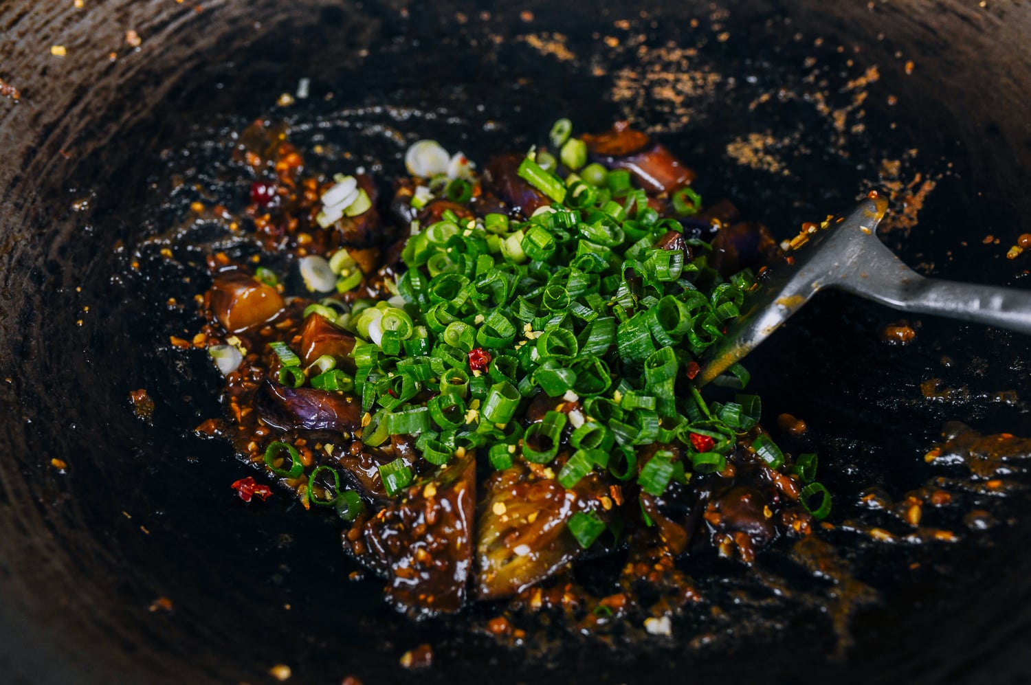 stirring scallions into eggplant with garlic sauce