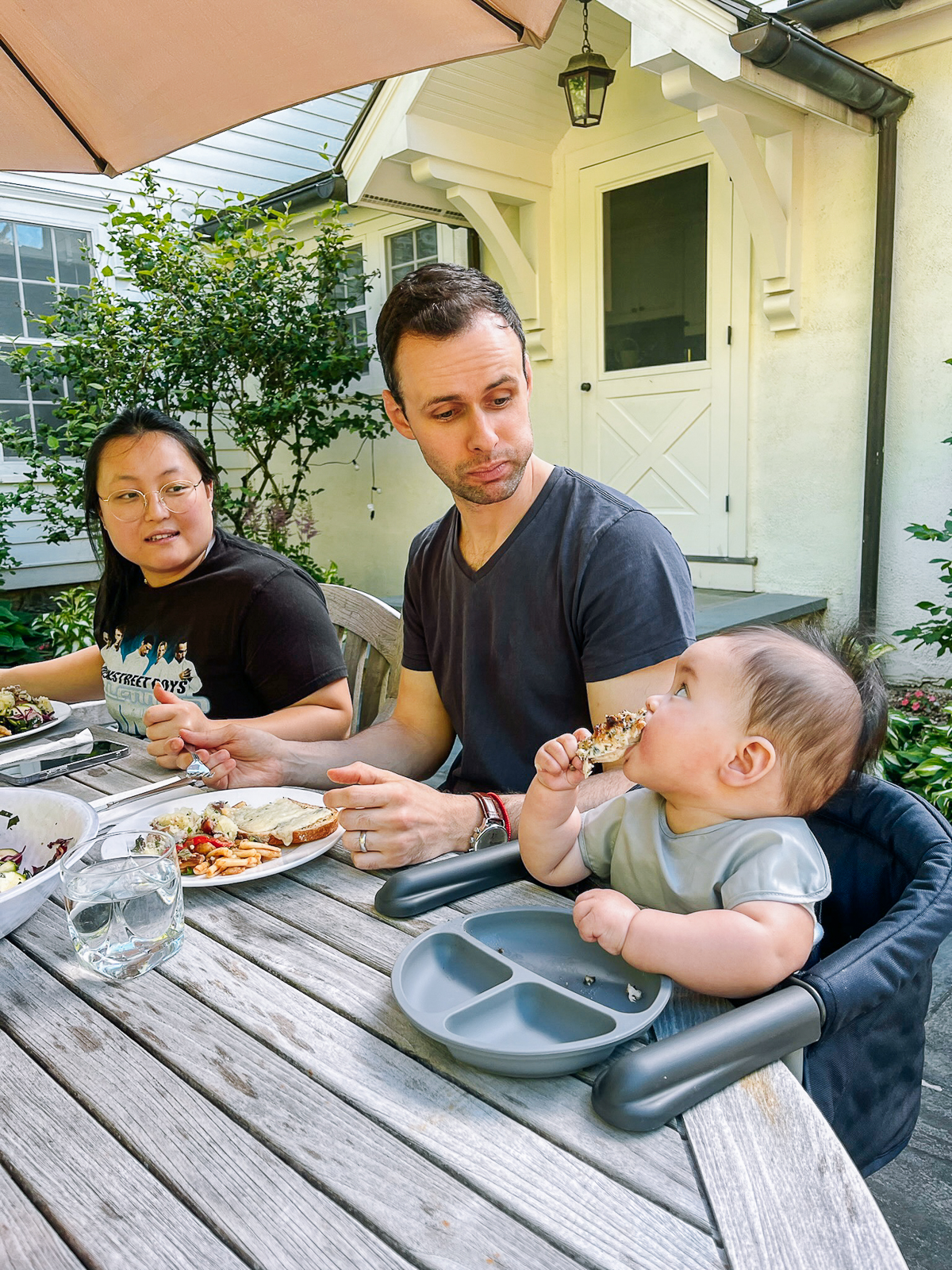 Kaitlin and Justin looking at Ethan eating chicken