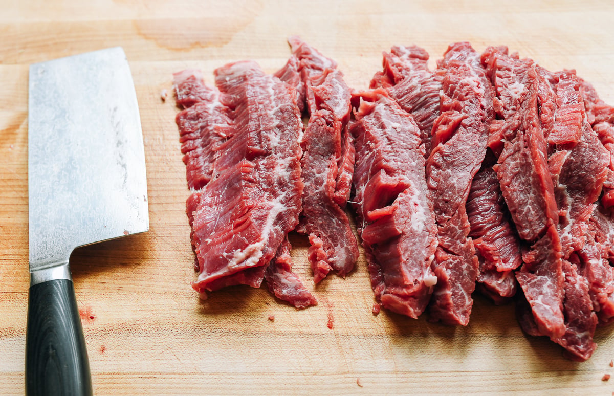 slicing beef flank steak into long thin slices.