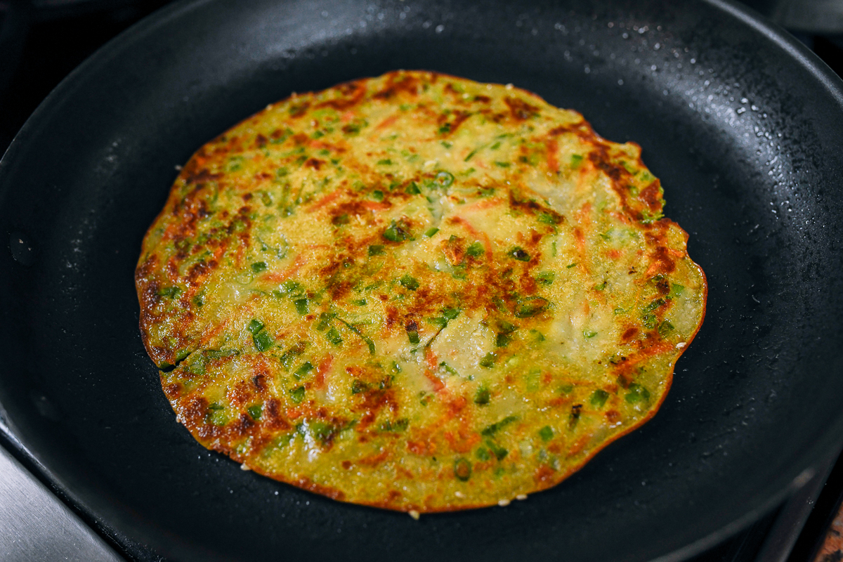 cooked vegetable pancake in frying pan