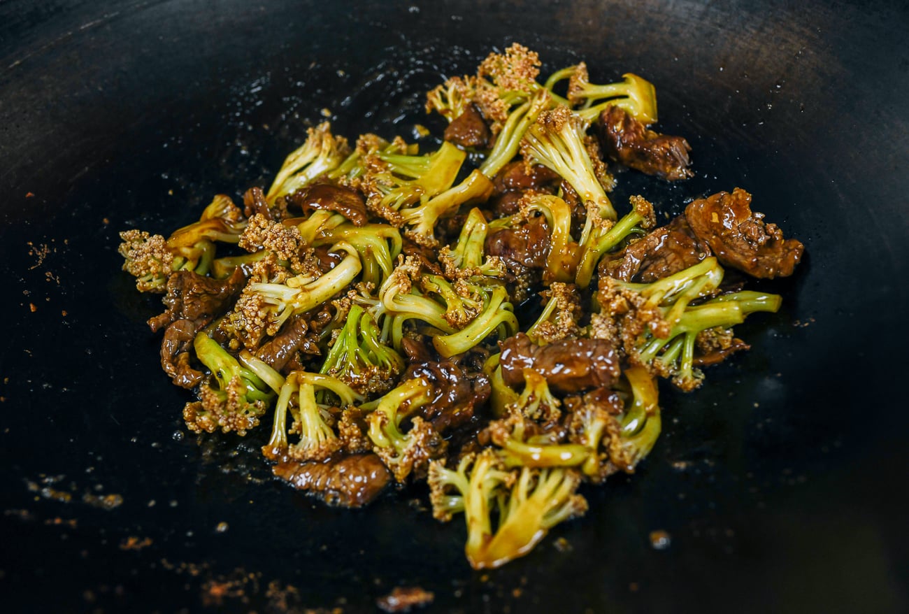 stir-frying beef and cauliflower in wok