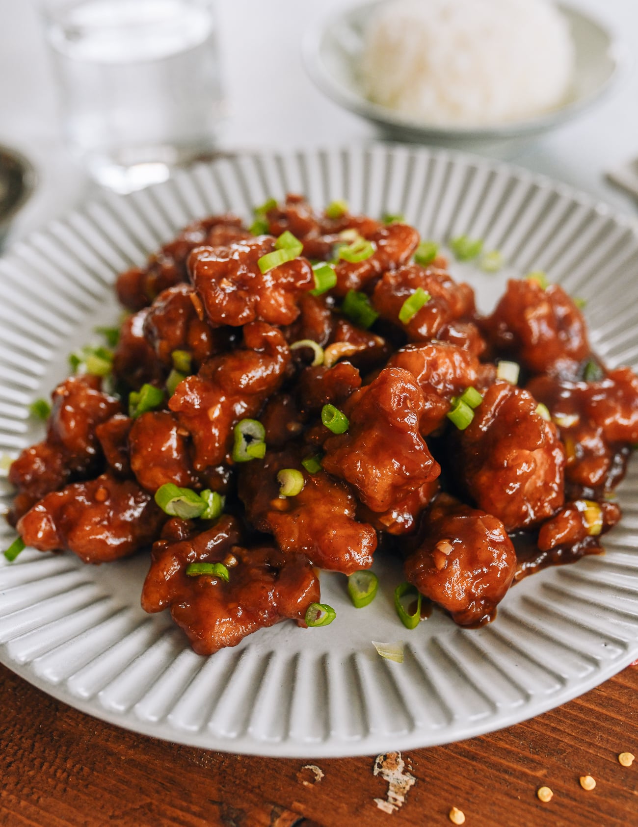 plate of firecracker chicken garnished with scallions