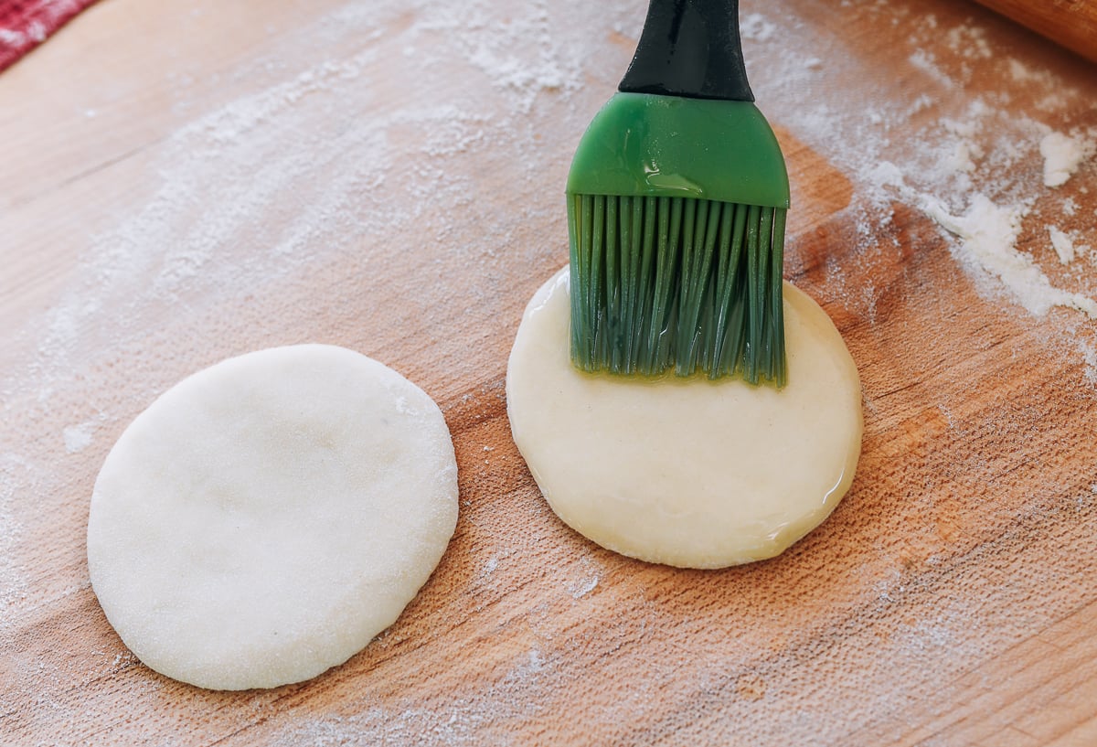 brushing dough circle with oil
