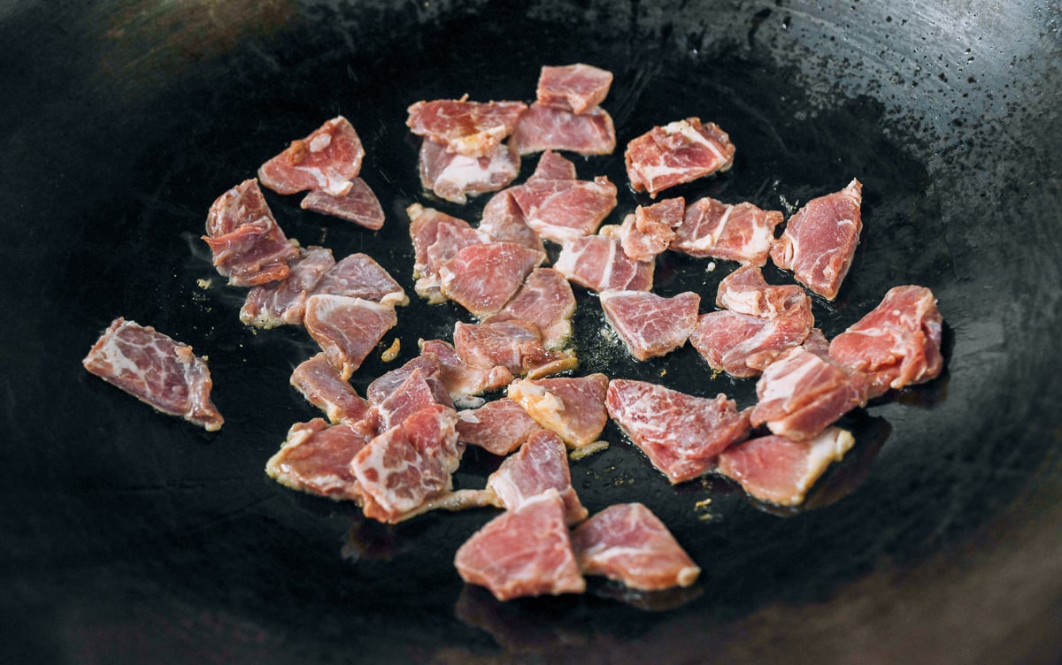 searing pork in wok