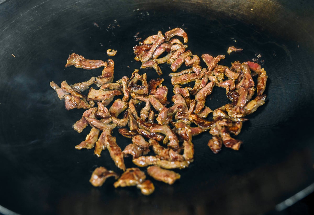 seared beef strips in wok