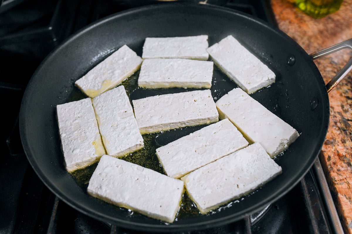 cornstarch coated tofu in oiled pan